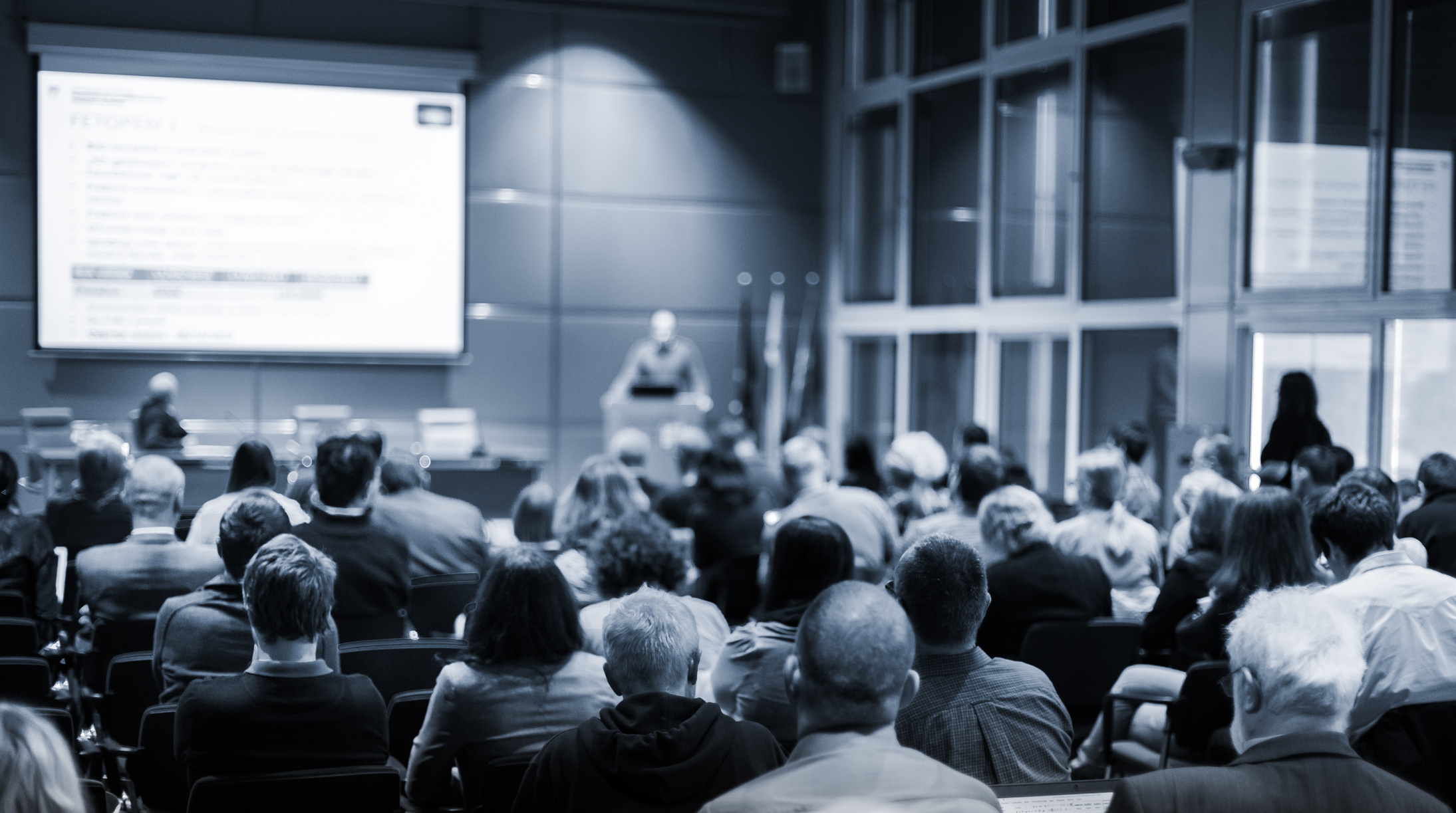 Audience in Lecture Hall Participating at Business Event.